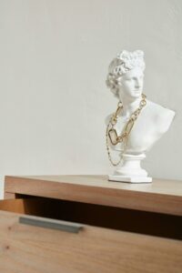 Artistic sculpture of a classical bust adorned with a chain necklace on a wooden table in Buenos Aires.
