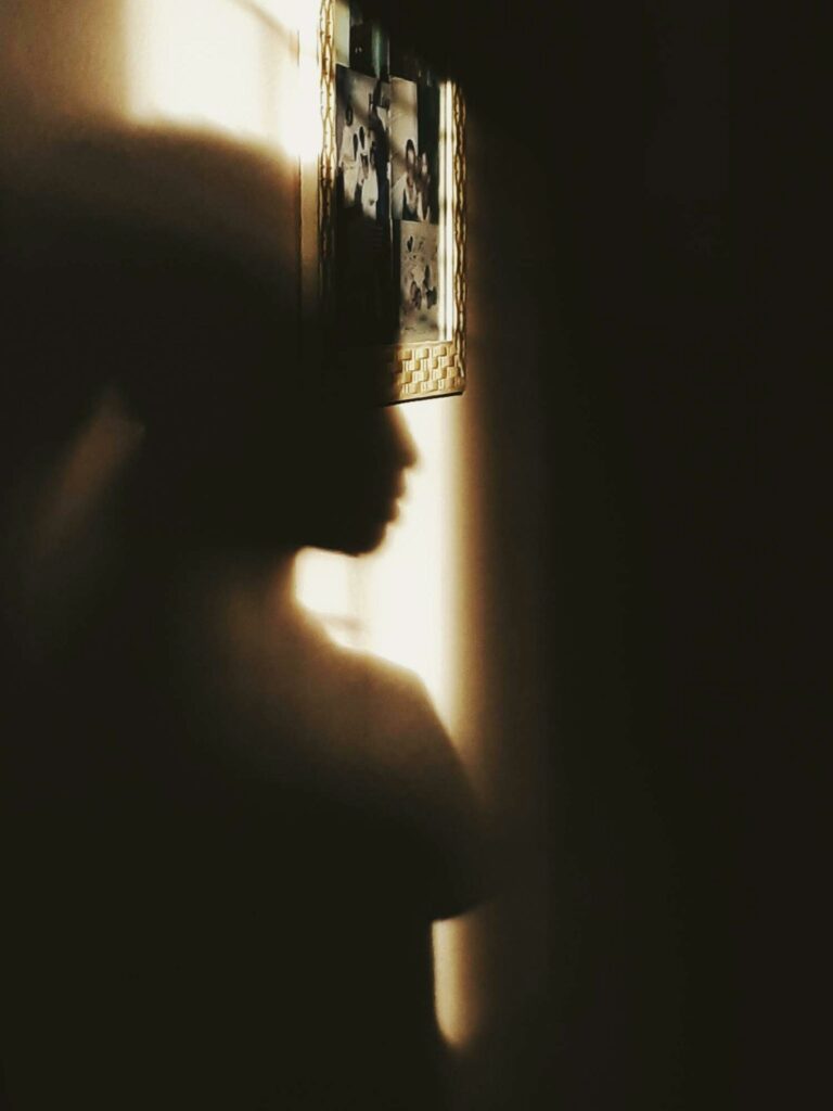 Shadow of person on wall in sunlight, creating a dramatic and artistic silhouette.