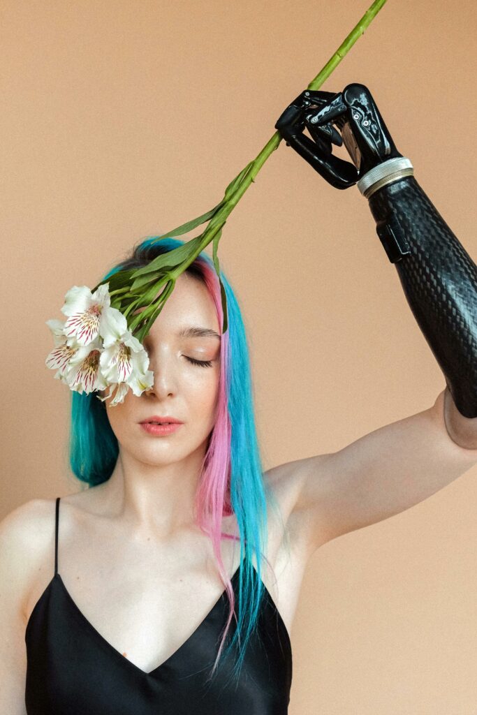 A captivating portrait of a woman with a prosthetic arm holding flowers, showcasing beauty and resilience.