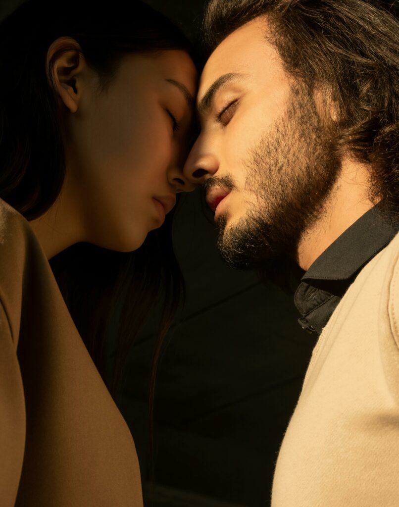 A close portrait of a couple with closed eyes sharing an intimate moment.