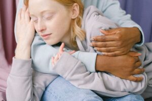 Close-up of an interracial couple embracing each other affectionately indoors.