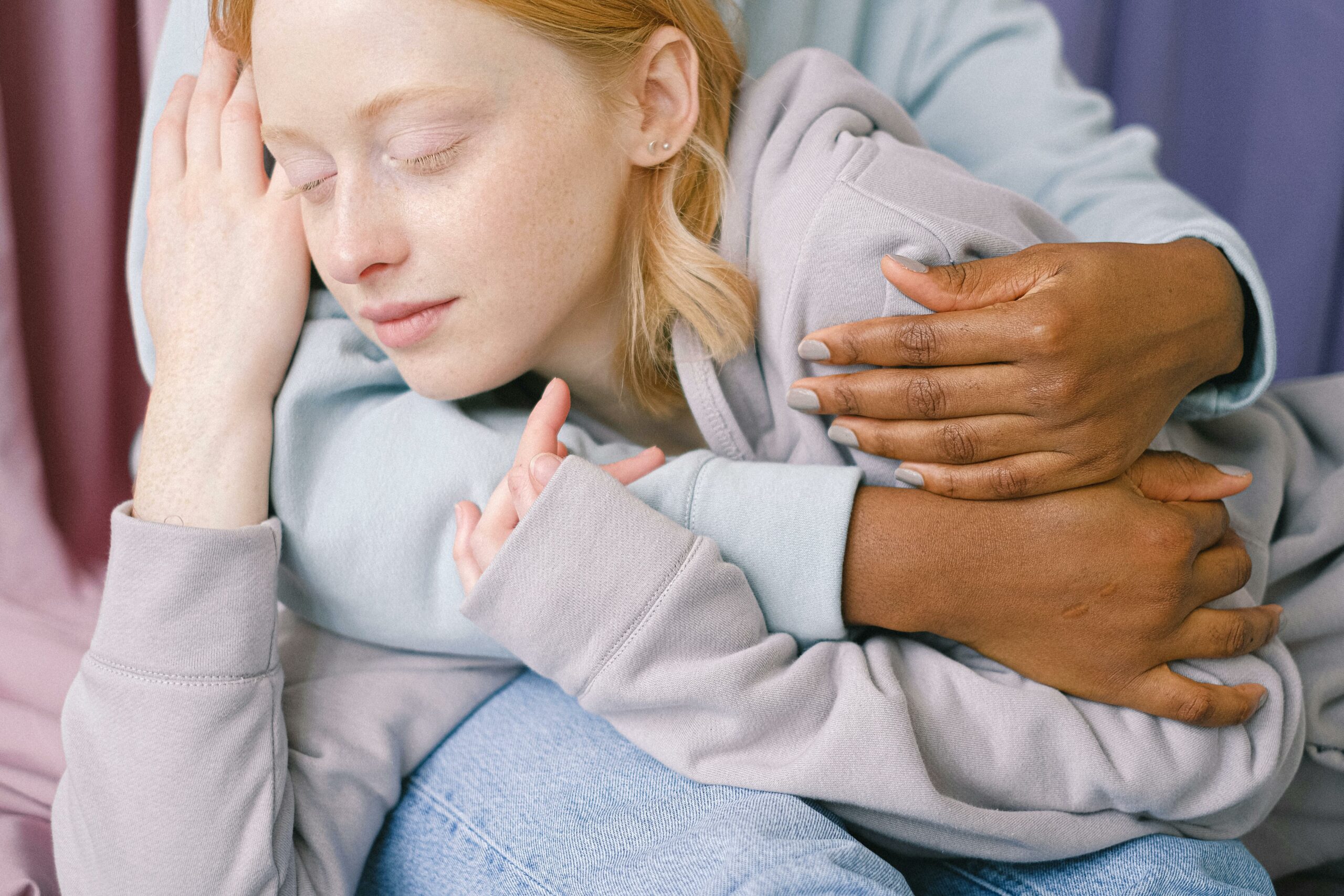 Close-up of an interracial couple embracing each other affectionately indoors.
