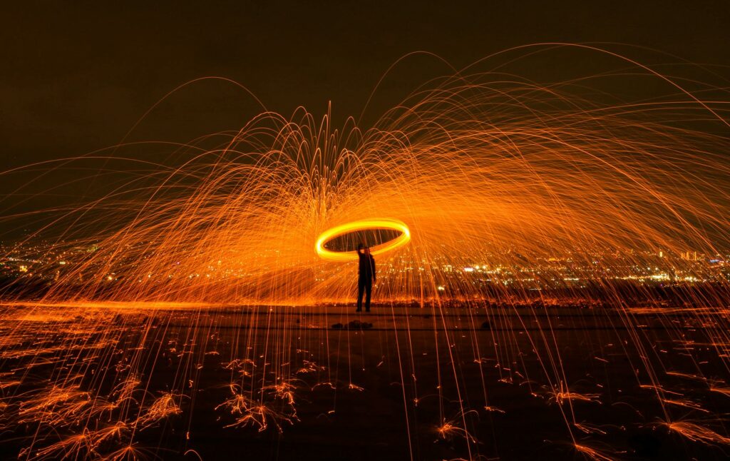 Captivating steel wool photography with dramatic sparks lighting up the night sky.