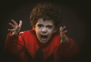 A young child expressing strong emotions during a studio portrait shoot.