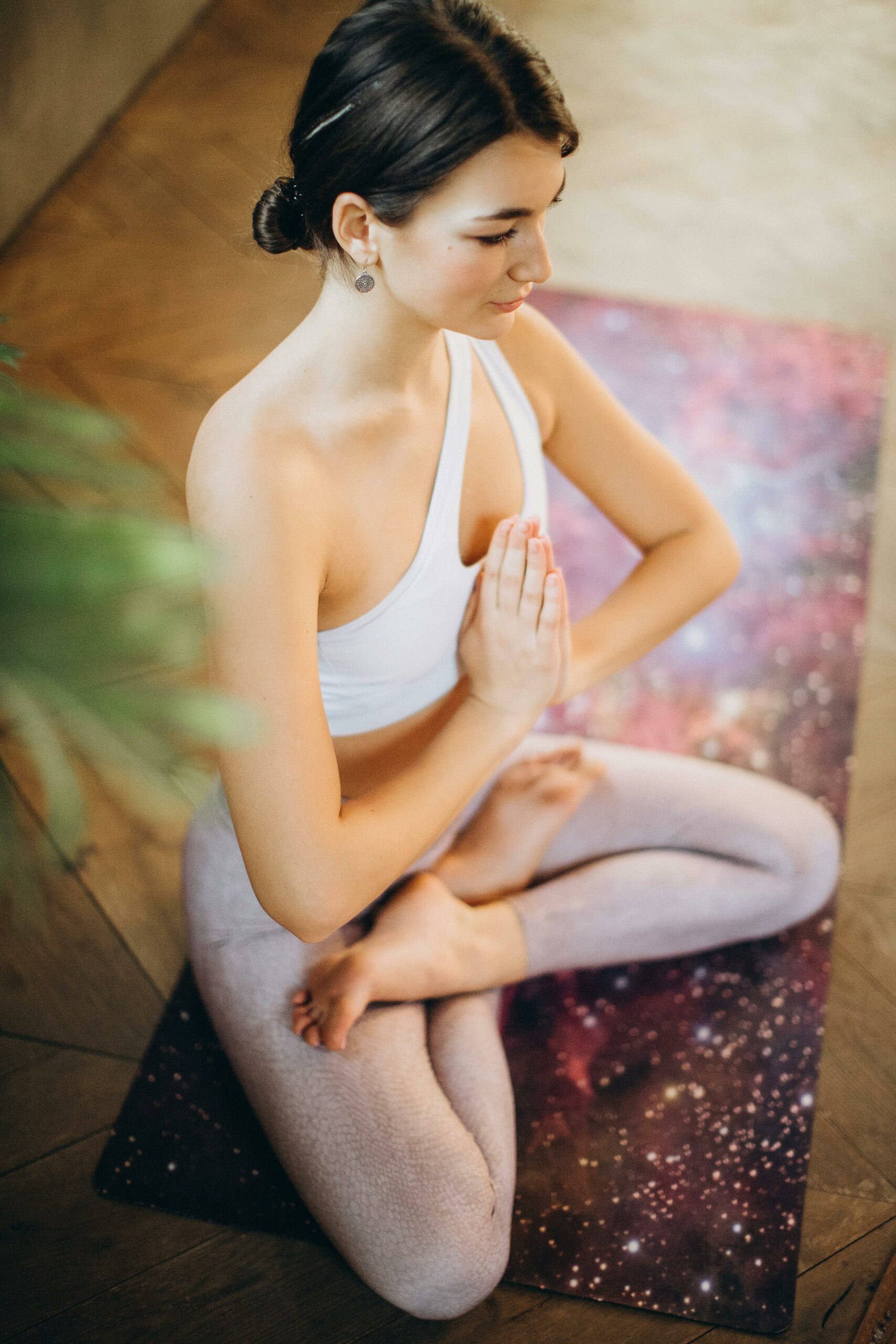 Woman in yoga pose indoors promoting mindfulness and relaxation.