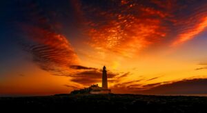 Silhouette of St Mary's Lighthouse against a vibrant sunset sky.