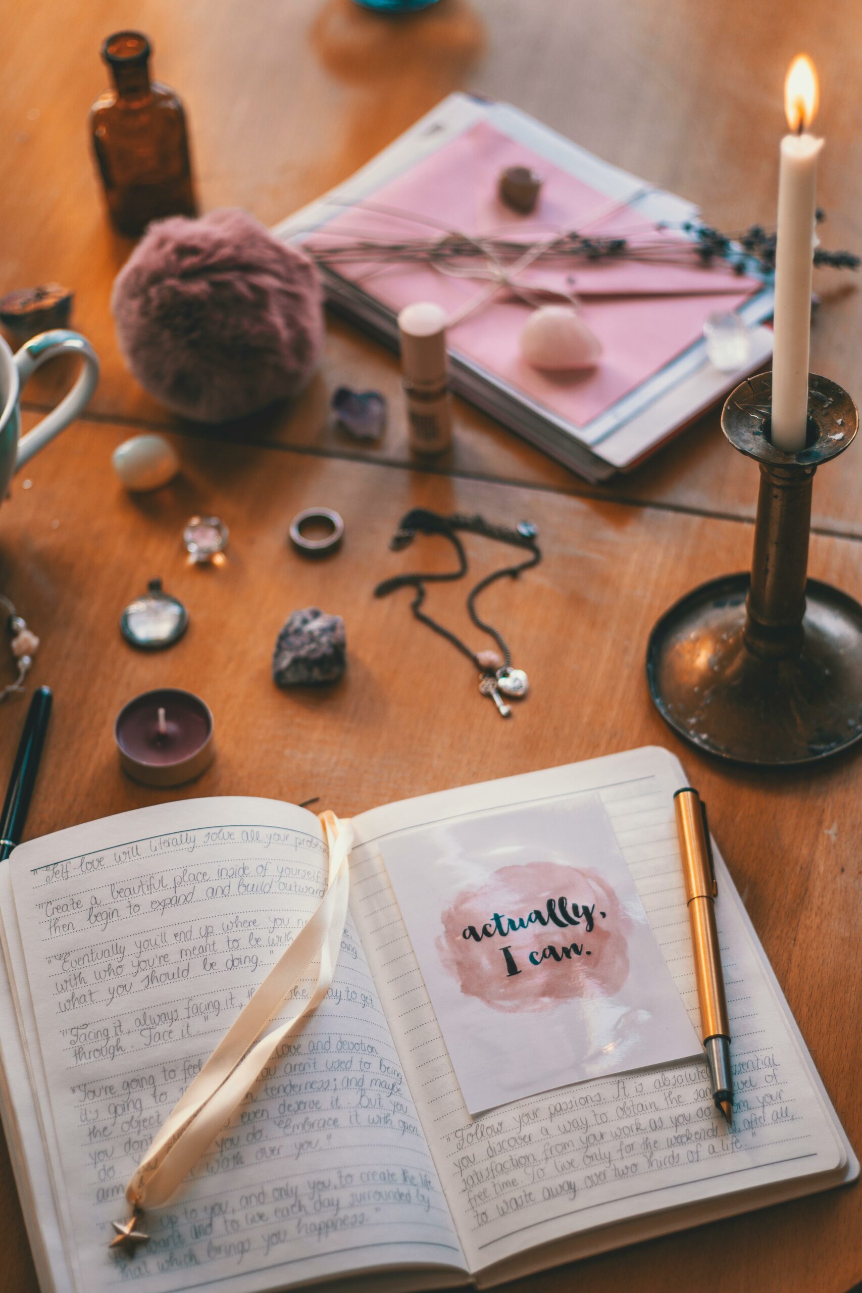 A warm indoor scene of a vintage writing desk adorned with candles, notebooks, and stationery.