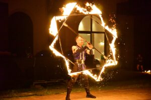 A skilled performer displaying a thrilling fire dance with a fiery star-shaped prop.
