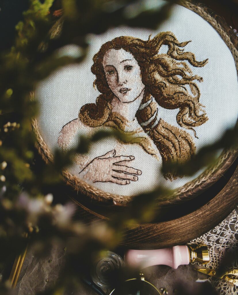 Detailed embroidery art depicting a vintage style portrait, creatively fashioned in a warm setting.