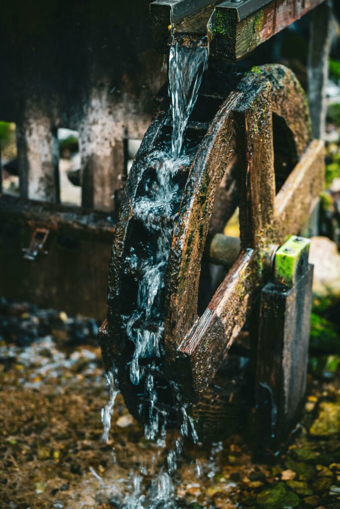 Charming rustic water wheel in Slovenian forest, capturing nature's beauty and classic engineering.