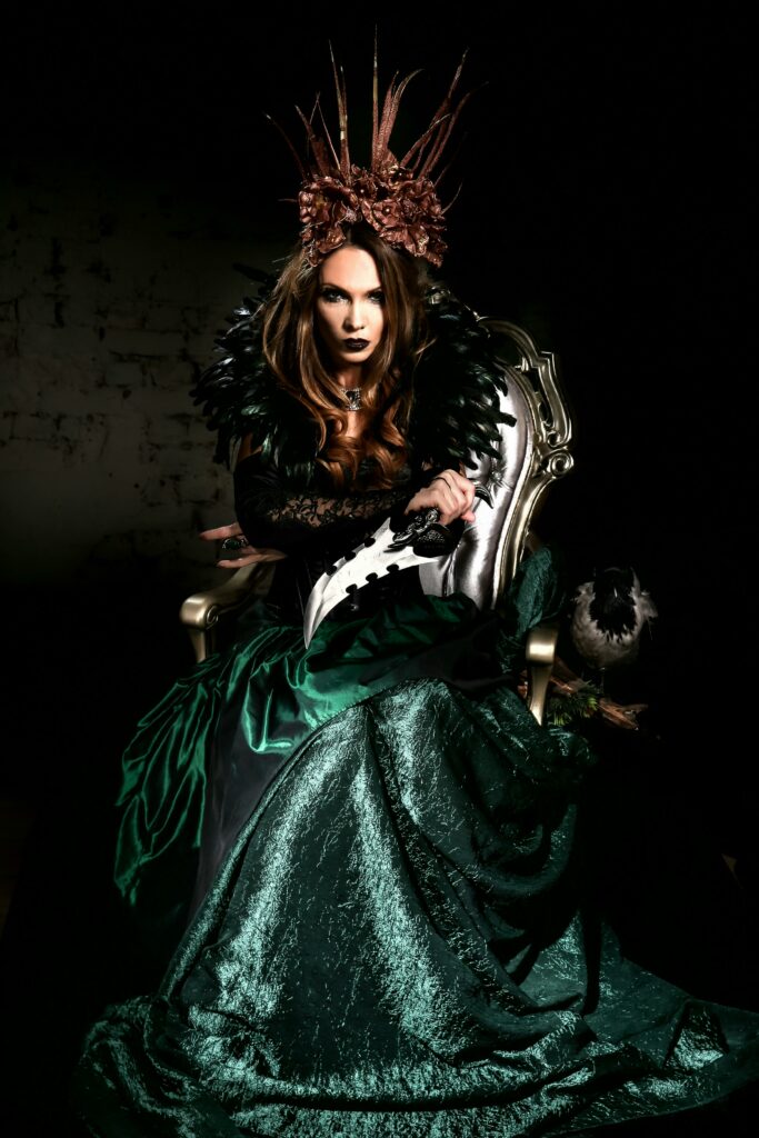 A dark fantasy portrait of a woman in an elaborate green costume, seated in a mystical atmosphere.