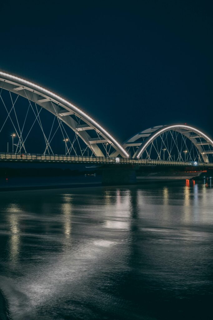 Beautiful night view of Zezelj Bridge reflecting over the Danube River in Novi Sad, Serbia.