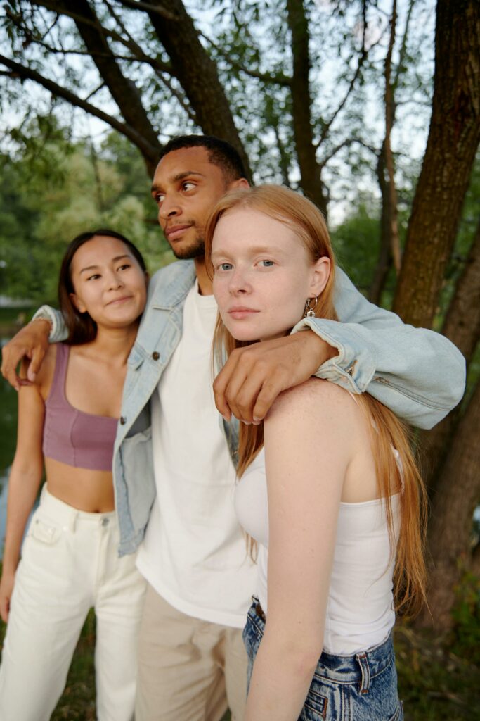Three young friends enjoying a moment together outdoors in a natural setting.