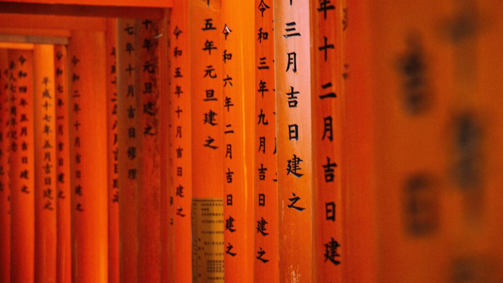 Detailed view of torii gates with Japanese inscriptions at Fushimi Inari Shrine, Kyoto.
