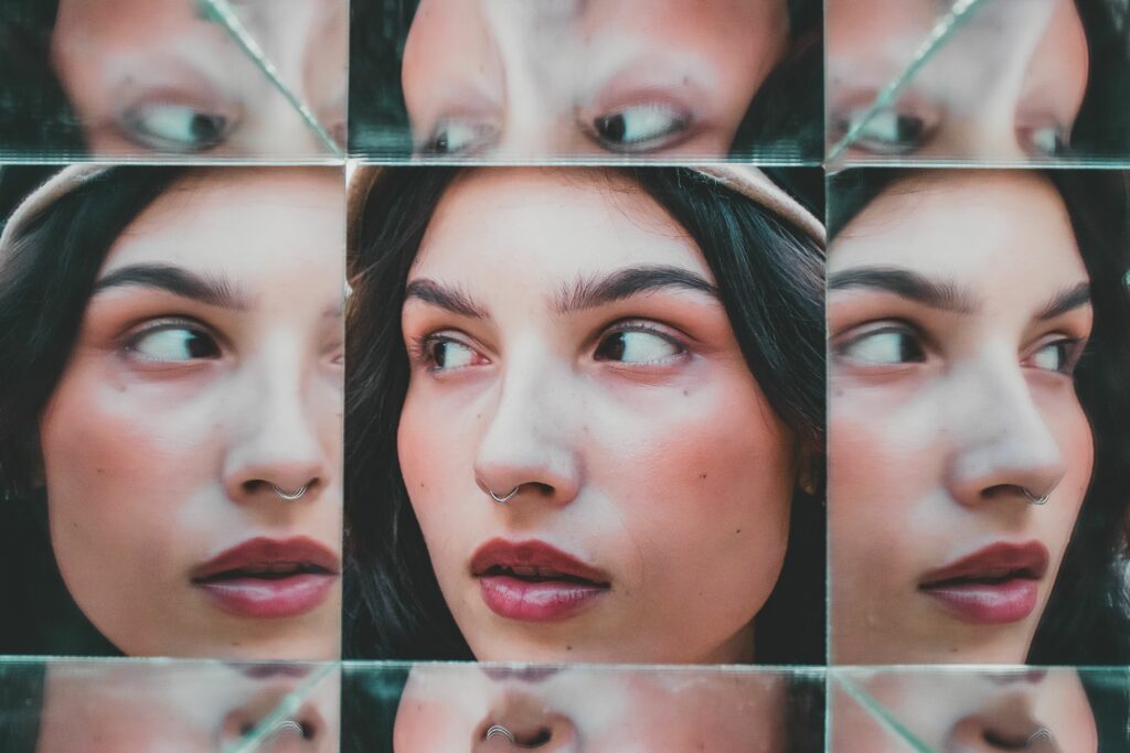 Artistic portrait of a woman with multiple reflections in mirrors, creating a unique visual effect.