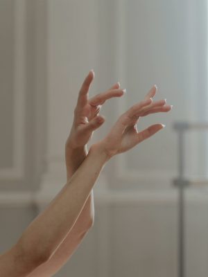 Close-up of a ballet dancer's hands captured in an elegant, graceful position, evoking movement and artistry.