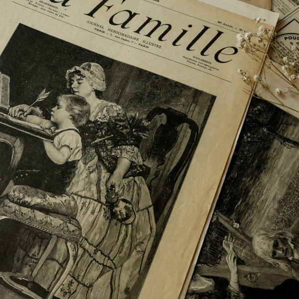 Artistic shot of vintage newspaper 'La Famille' with classic illustrations. Perfect for history enthusiasts.