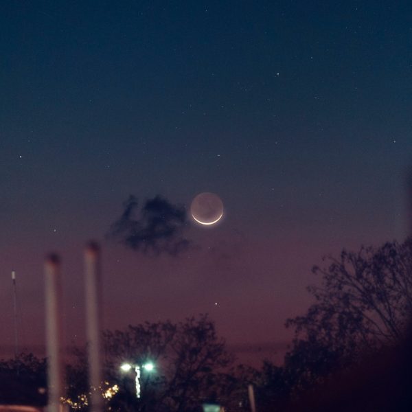 A serene night sky in Akumal with a crescent moon and starry backdrop, perfect for astronomy lovers.