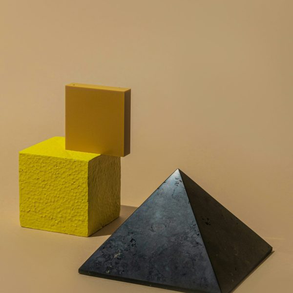 Abstract photo of cubes and a pyramid in a studio, emphasizing geometry.